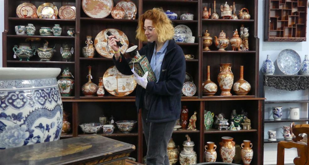 Auctioneer studying Asian art