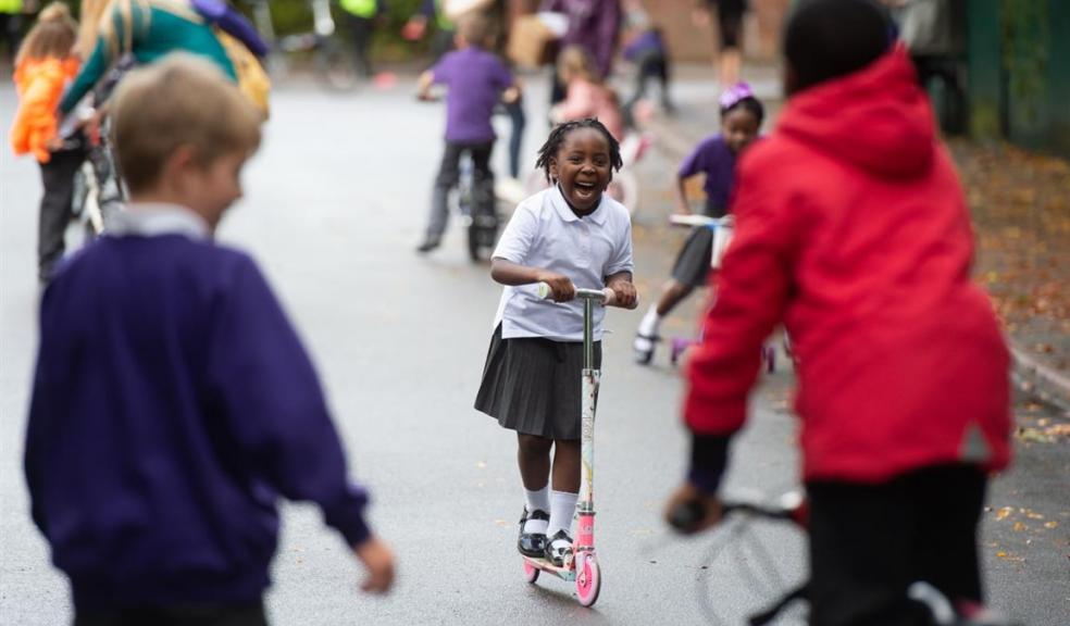 Photo of children playing on scooters and bikes