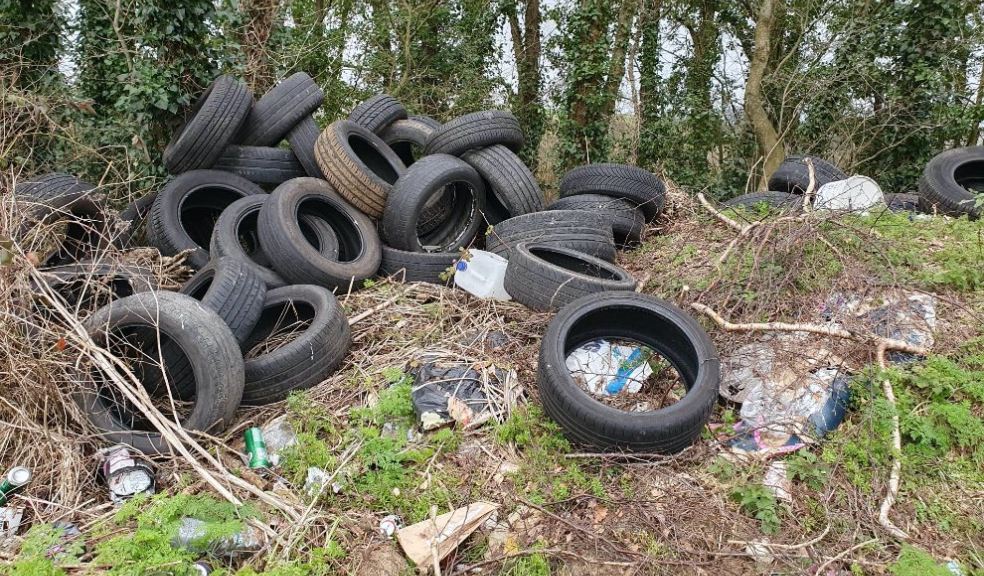 A photo of a fly-tip in East Devon with a pile of tyres