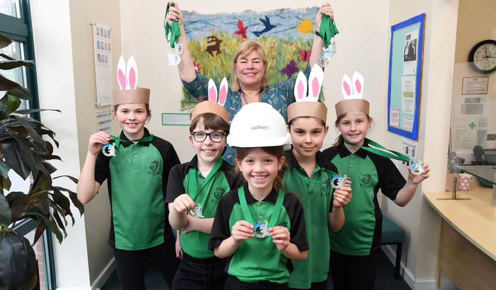 Anne Hawkins, headteacher of Willand School, and pupils with the Easter medals donated by Bellway.