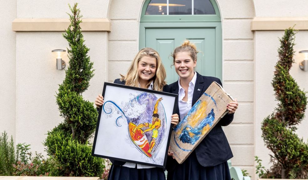 Blundells students Arby Parker and Izzy Collins outside the Edenstone show home at The Orchards in Sampford Peverell, where their artwork is on display