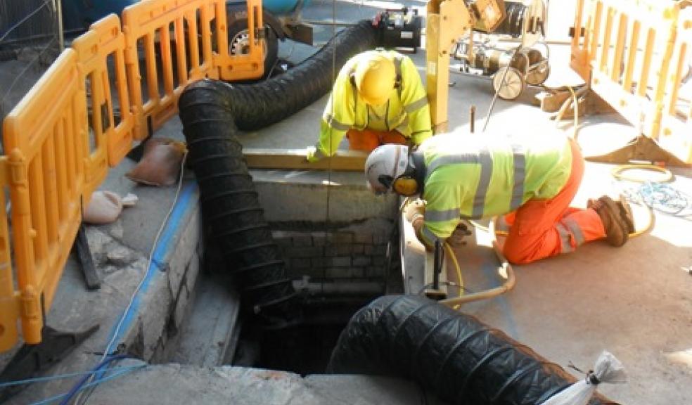 A crew carrying out keyhole repairs through the bottom of a manhole chamber