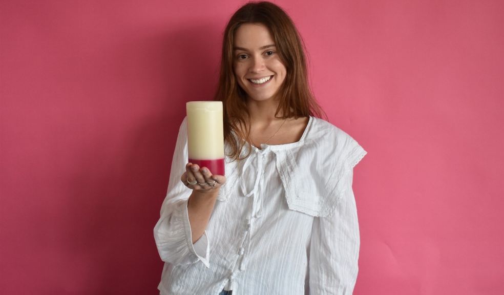 Woman holding a recycled charity candle for Missing People