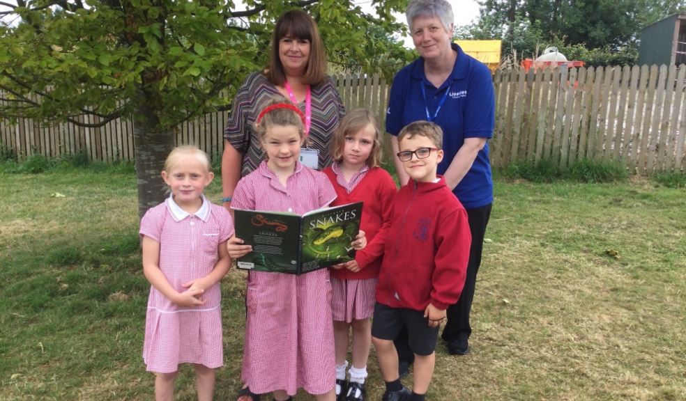 Headteacher Melody Sterry, Alison Knight from LiveWest with pupils from Lamerton C of E Primary School with a book purchased with the book tokens.