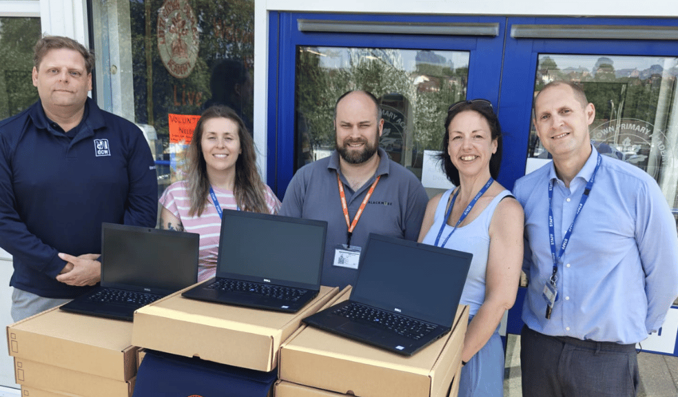 Staff standing with new refurbished laptops for pupils Staff standing with new refurbished laptops for pupils