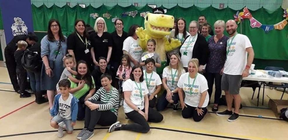Members of the Together for Childhood team with Pantosaurus