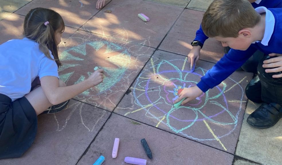 School children having fun in the autumn sunshine creating beautiful rangoli-inspired patterns. Photo: Cedarwood Primary School