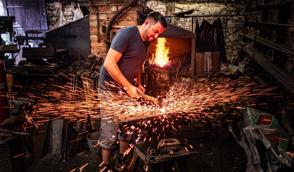 Simon Hall sends sparks flying at the anvil at Branscombe, East Devon. Image: National Trust Images, Eric McDonald