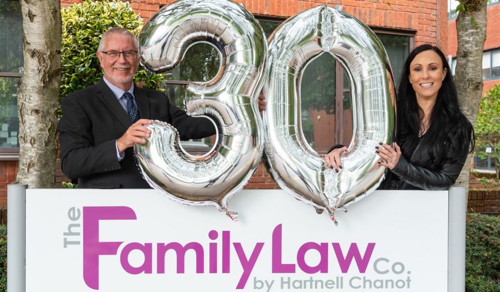 Two solicitors from The Family Law Company holding celebration balloons
