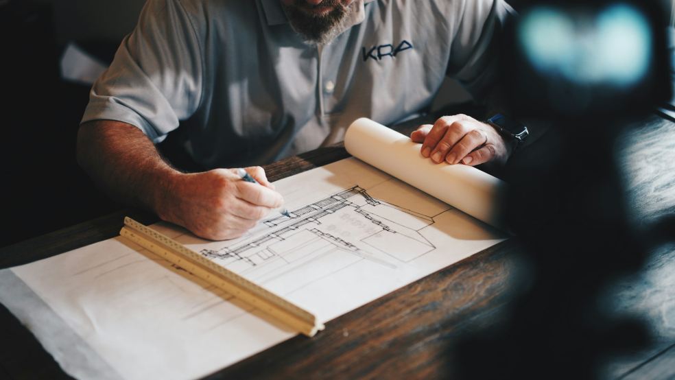 Architect reviewing a site drainage plan on a desk