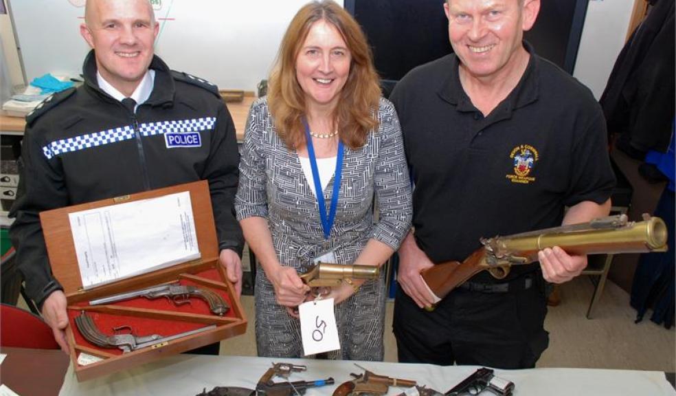 Chief Inspector Daniel Evans with antique duelling pistols, Firearms and Explosives Licensing Manager Michelle Mounsey with WW1 flare pistol, Armourer Mike Barker with replica blunderbuss.