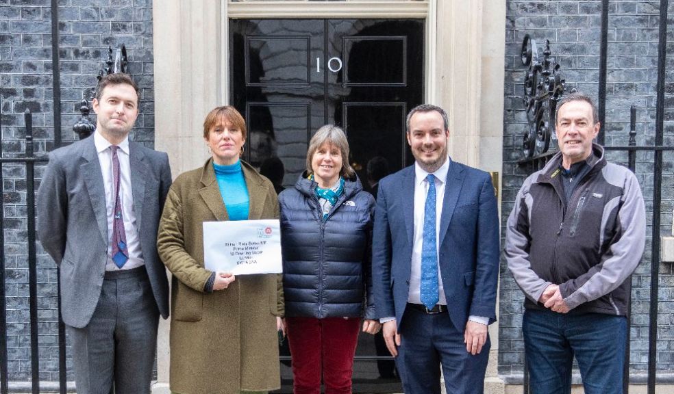 Picture of 4 people standing outside 10 Downing Street with petition