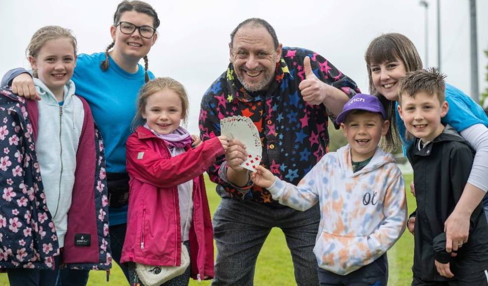 Photo caption: Magician Ozzy D pictured with Fliss Cisneros and Laura-Jane Alford from Willand School PTFA and pupils from Willand School.