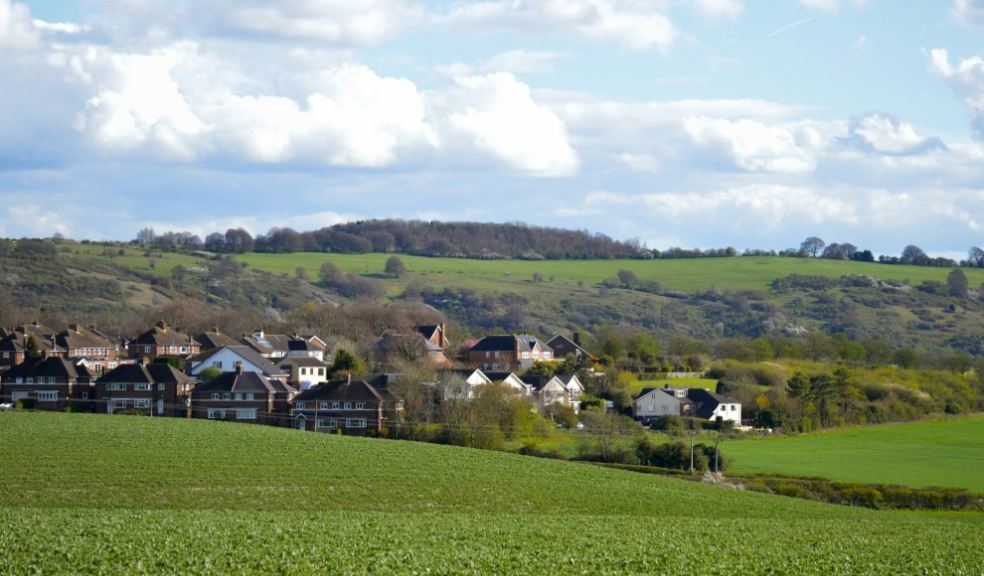 A tractor working farmland in rolling English countryside