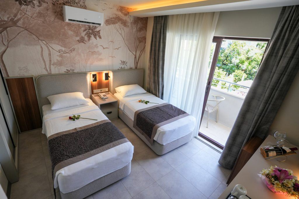 two beds in a bedroom at the Ida hotel in Icmeler 