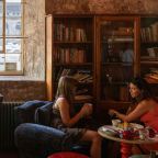 A photograph of people at Royal William Yard with a bookcase behind them