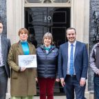 Picture of 4 people standing outside 10 Downing Street with petition