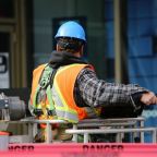 Construction worker on a UK building site wearing a hard hat and high visibility jacket