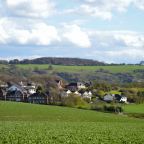 A tractor working farmland in rolling English countryside