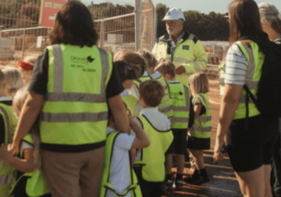 School children stood with teachers and construction director at Coln Signature Homes building site