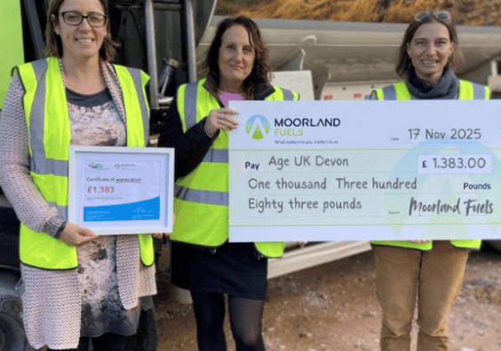 3 women holding up big cheque for Age UK Devon