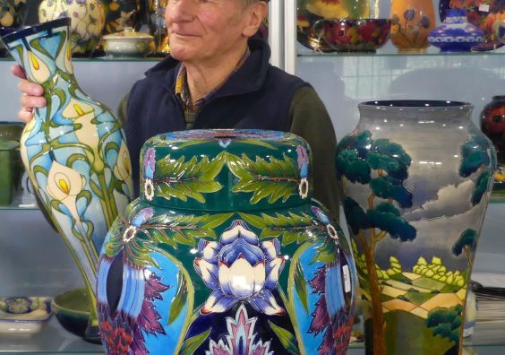 Auctioneer with examples of Moorcroft Pottery