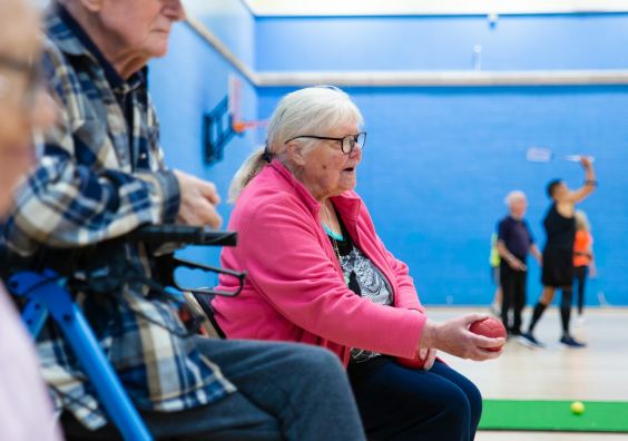 A diverse group of people talking together in a bright community centre