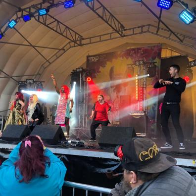 Acting on a stage, man next to it doing sign language to the audience. 