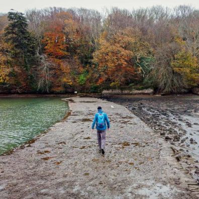 Student walking across the estuary