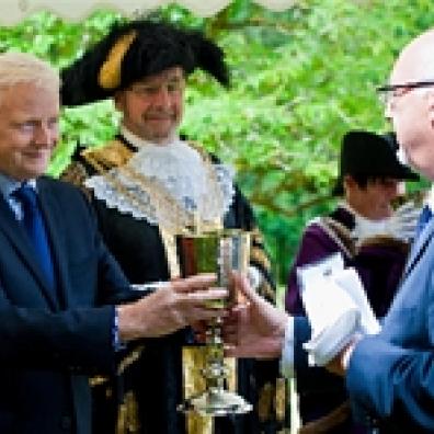 South West Water's Operations Director, Dr Stephen Bird, presents the company's Chief Executive, Chris Loughlin, with one of the "loving cups" during the Fishing Feast ceremony as the Lord Mayor, Councillor Michael Fox, looks on