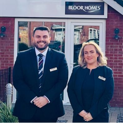 Two members of Bloor Homes' sales team outside the sales centre ready to welcome visitors