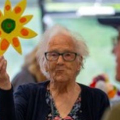 Old lady holding sunflower at library