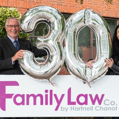 Two solicitors from The Family Law Company holding celebration balloons