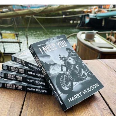 Five copies of I Need You by Harry Hudson on a table at Charlestown Harbour