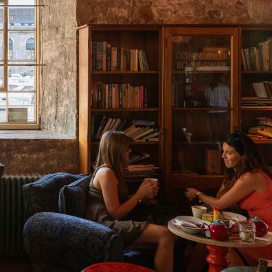 A photograph of people at Royal William Yard with a bookcase behind them