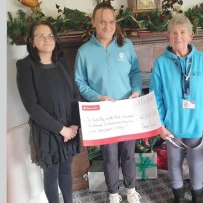 Maria Nolan and Sophie Page present the fundraising cheque to Guide Dogs volunteer Di Hatchett and g