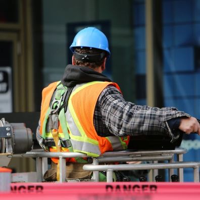 Construction worker on a UK building site wearing a hard hat and high visibility jacket