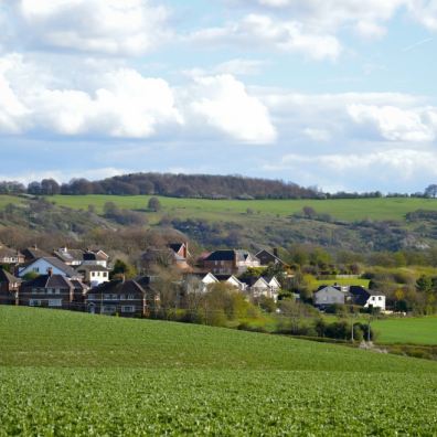 A tractor working farmland in rolling English countryside