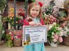 Young girl at Otter Garden Centres holding a prize winning certificate