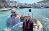 A family on a boat leaving harbour