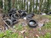A photo of a fly-tip in East Devon with a pile of tyres