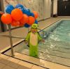 Baby in fancy dress stood by pool
