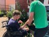 charity worker helping young boy in wheelchair 