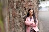 Solicitor in pink jacket leaning against a wall