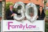 Two solicitors from The Family Law Company holding celebration balloons