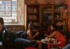 A photograph of people at Royal William Yard with a bookcase behind them