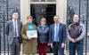 Picture of 4 people standing outside 10 Downing Street with petition